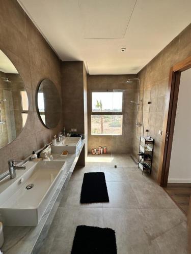 a bathroom with two sinks and a tub and a mirror at Les Palms De L’Atlas in Marrakesh