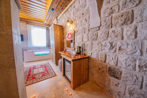 uma casa de banho com paredes de pedra, um balcão e um lavatório. em Remus Romulus Cappadocia em Üçhisar