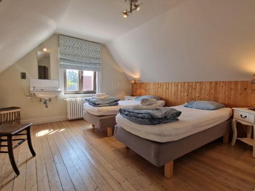 een slaapkamer met twee bedden en een raam bij Villa Dageraad in De Panne