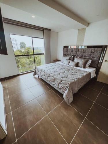 una camera con un grande letto e una grande finestra di exclusivo apto zona privilegiada a Pereira
