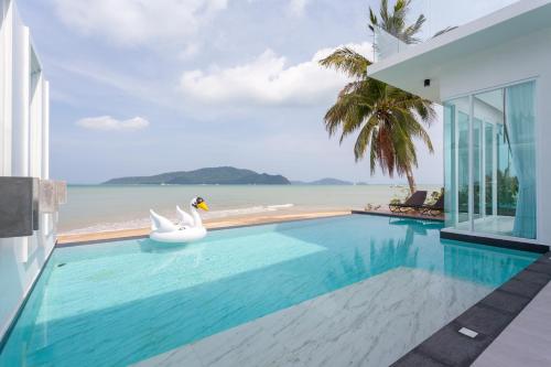 a swimming pool with a view of the ocean at Fisherman Way Beach Villa - SHA Extra Plus in Rawai Beach