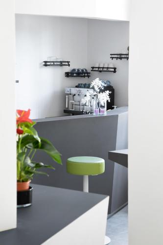 a bar with a green stool next to a counter at Bohoostel in Bologna