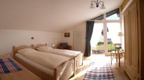 1 Schlafzimmer mit 2 Betten und einem großen Fenster in der Unterkunft Sonnentau -909- in Mittenwald