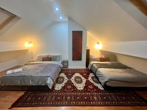 een slaapkamer op zolder met 2 bedden en een tapijt bij House in the Heart of Manchester in Manchester