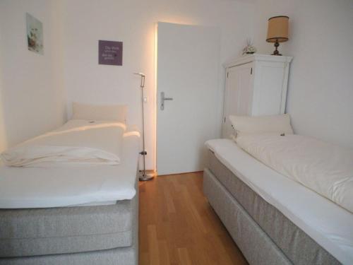 - 2 lits dans une petite chambre avec un couvre-lit dans l'établissement Rustico -301-, à Mittenwald
