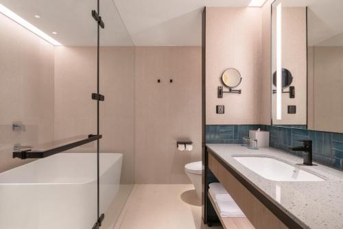 a bathroom with a sink and a tub and a toilet at Four Points by Sheraton Taipei Bali in Bali