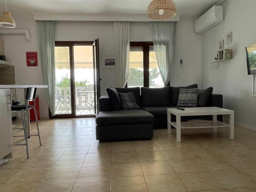 a living room with a black couch and a table at V&Z Apartment Seaview in Ofrínion
