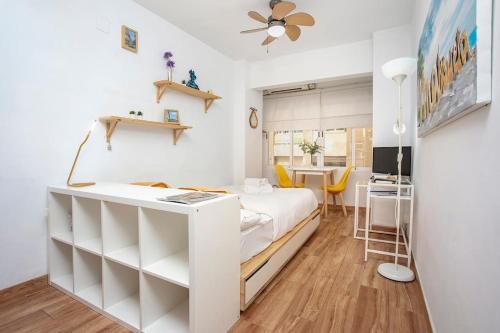 Habitación pequeña con cama y escritorio. en MÁLAGA CENTER, MALAGUETA BEACh, en Málaga