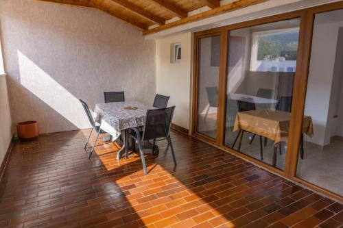 a room with a table and chairs and a dining room at Apartments Petrica in Baška