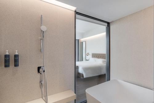 a bathroom with a shower with a glass door at Four Points by Sheraton Taipei Bali in Bali