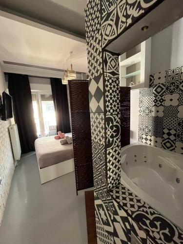 a bathroom with a tub and a bedroom with a bed at VIP Apt. Pezodromos Kalamarias in Thessaloniki