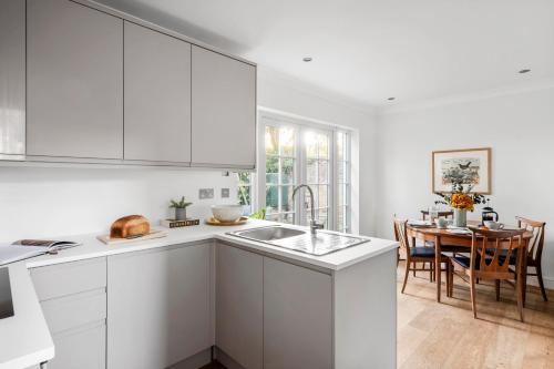a white kitchen with a sink and a table at Beautiful Apartment Wendens Ambo in Wendens Ambo