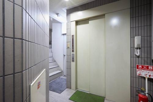 a hallway with a door and a green rug at TokyoGuest Akihabara in Tokyo
