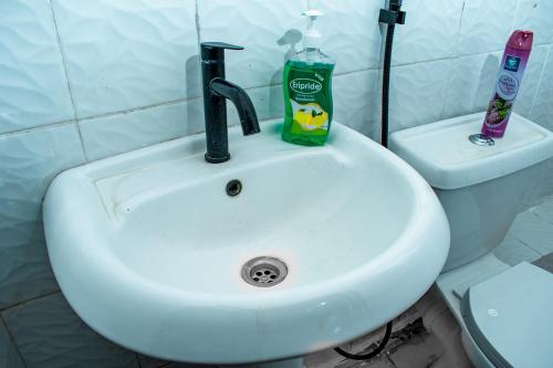 a white bathroom sink with a bottle of toothpaste and a soap at Urban Elegance in Nairobi