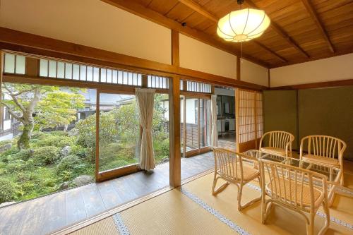 a room with a table and chairs and a large window at Koyasan Shukubo Jokiin in Koyasan