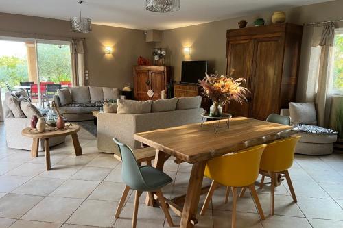 un salon avec une table et des chaises en bois dans l'établissement LAcacia, à Plaissan