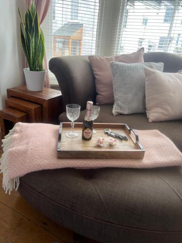 a tray of food and wine glasses on a couch at The Captain's House in Looe