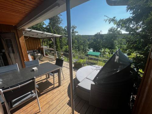 a patio with a table and chairs on a deck at Ferienhaus Zeulenrodaer Meer in Stelzendorf