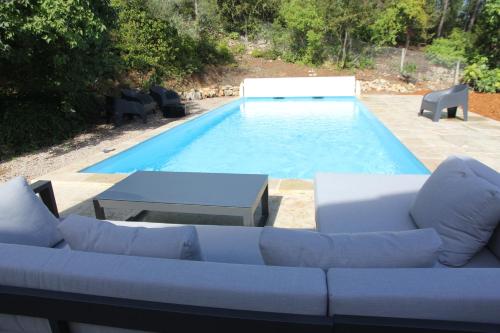 a pool with a couch and chairs in front of it at Location gîte dans le var in Le Thoronet