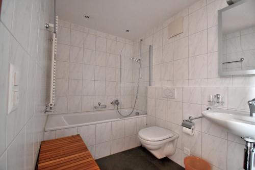 a white bathroom with a toilet and a sink at 2.5 Puoz Fewo Bernina in Samedan