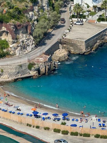 a beach with umbrellas and people in the water at Villaggio Villa Lubrense in Massa Lubrense