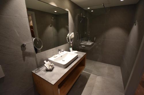 a bathroom with a sink and a mirror at Hotel Lago Maggiore - Welcome! in Locarno