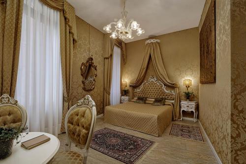 a bedroom with a bed and a table and a chandelier at B&B Ca' Bonvicini in Venice
