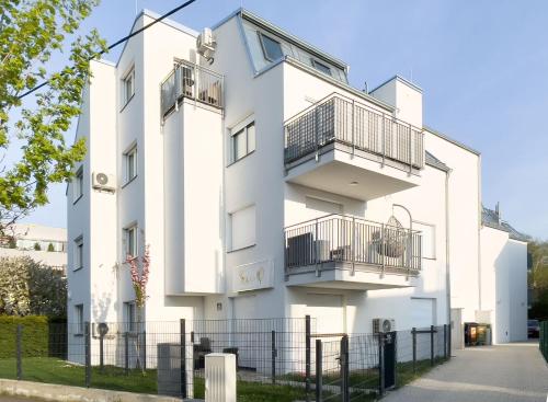 a white building with two balconies on it at Vienna's Modern Black Beauty - Couples & Family-Friendly apartment in Vienna