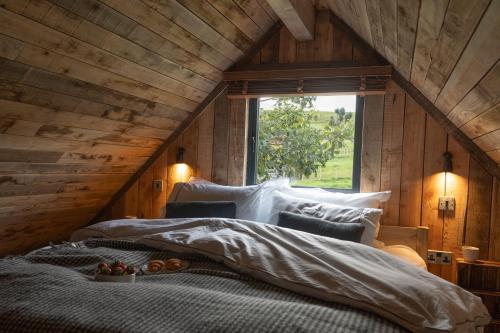 Un dormitorio con una cama grande con ventana. en Woolly Wood Cabins - Bryn, en Llandrindod Wells