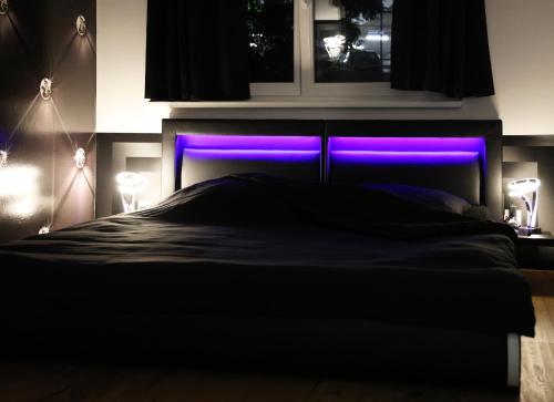 a bedroom with a bed with a purple headboard at Vienna's Modern Black Beauty - Couples & Family-Friendly apartment in Vienna