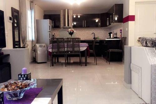 Il comprend une cuisine et une salle à manger avec une table et un réfrigérateur. dans l'établissement Villa paisible et agréable, à Morières-lès-Avignon