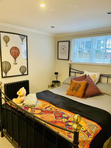 um quarto com uma cama com um urso de peluche sentado sobre ele em Grade II boho home in the heart of Oxford St. em Southampton