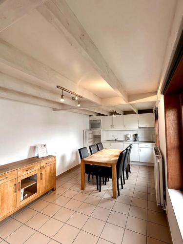 a kitchen with a wooden table and black chairs at Zeepark Haerendycke in Wenduine