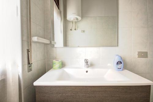 y baño con lavabo blanco y espejo. en MilanRentals - Teodorico Apartment, en Milán