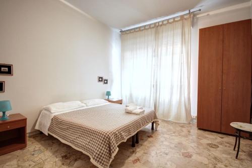 a bedroom with a bed and a large window at MilanRentals - Teodorico Apartment in Milan