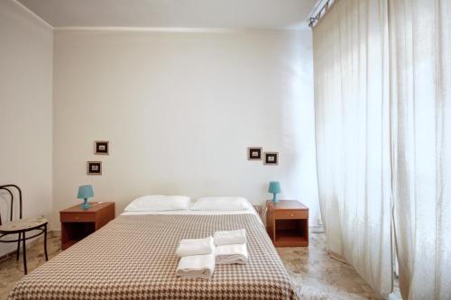 a white bedroom with a bed with towels on it at MilanRentals - Teodorico Apartment in Milan