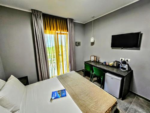 a hotel room with a bed and a desk and a television at A Casa di Alessandra - Rooms in Castellabate