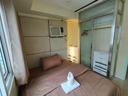 a small bedroom with a bed with a towel on it at Premiere Haven MOA Staycation in Manila