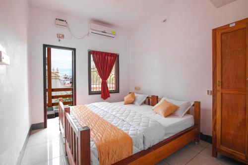 Schlafzimmer mit einem großen Bett und einem Fenster in der Unterkunft Manora Residency in Puducherry