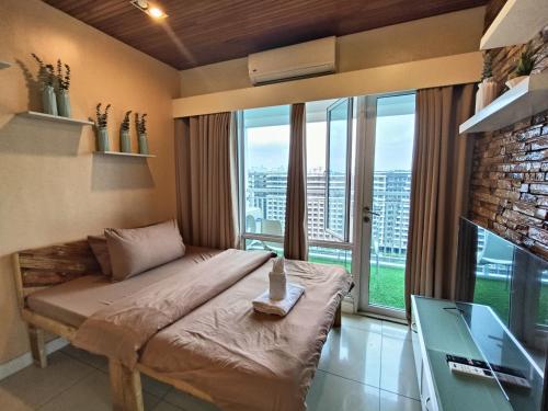 een slaapkamer met een bed voor een groot raam bij PREMIERE HAVEN at Sea Residences Condominium in Manilla