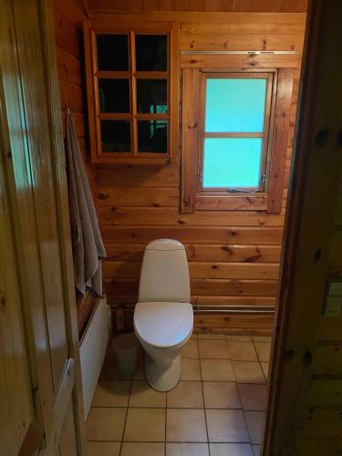 - une salle de bains avec toilettes dans une cabine en bois dans l'établissement Family-friendly Cottage By Stoense Beach, à Tranekær