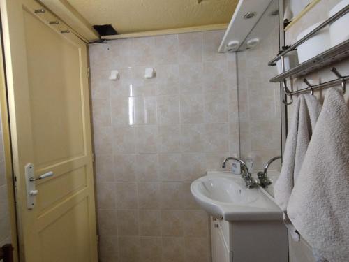 La petite salle de bains est pourvue d'un lavabo et d'une douche. dans l'établissement Giallo, à Paris