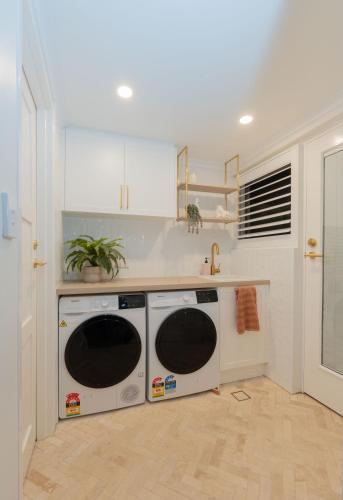 a kitchen with two washer and dryer at Seaside Villa Steps to Beach, Cafes, Boutiques in Brighton
