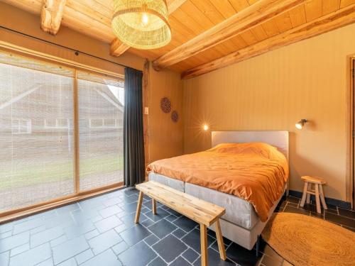 1 dormitorio con cama y techo de madera en Holiday farm in Ijhorst in green surroundings, en IJhorst