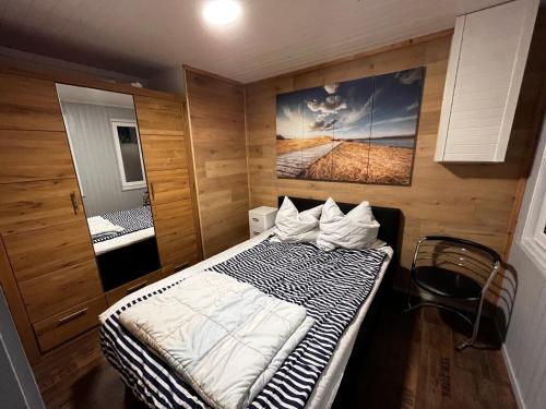 a small room with a bed and a picture on the wall at Ferienhaus Zeulenrodaer Meer in Stelzendorf