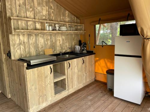 La cuisine est équipée d'un réfrigérateur blanc et d'un évier. dans l'établissement Lodges & Nature - 47, à Avignon