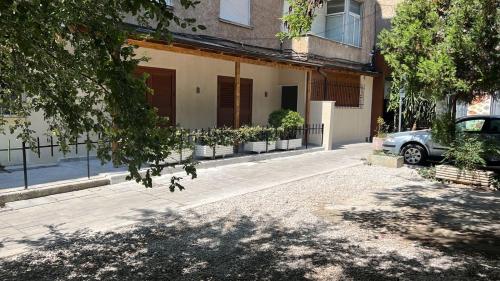 samochód zaparkowany przed domem z doniczkami w obiekcie Pietro Guesthouse 3 w Tiranie