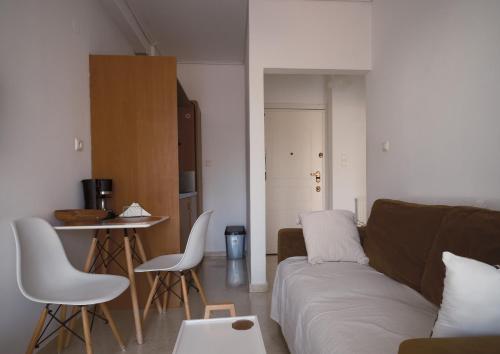 a living room with a couch and a table and chairs at tripoli center apartment in Tripolis