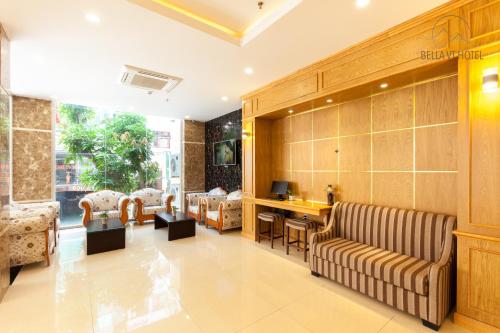 a lobby with a couch and a table and chairs at BELLA VT HOTEL in Vung Tau