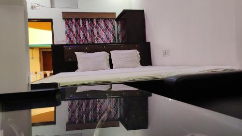 a bed in a small room with a mirror at Sea Land Mandarmani in Mandarmoni